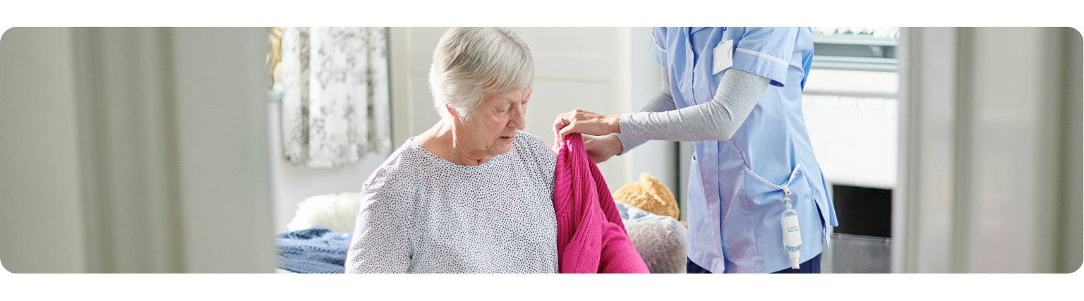 Nurse helping elderly woman with her coat