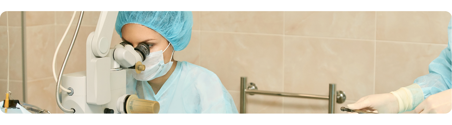 Medical professional using microscope during eye surgery
